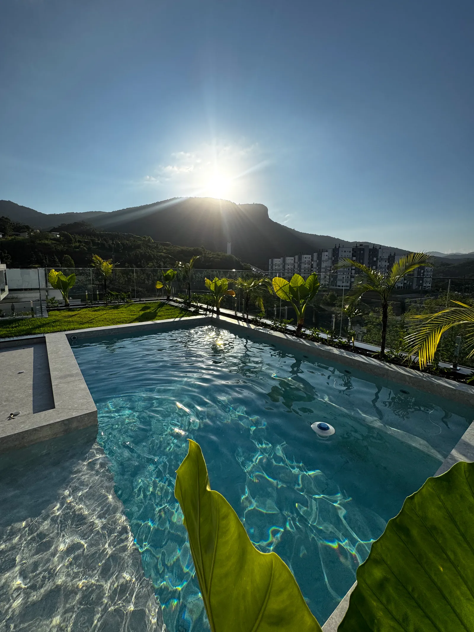 Piscina da Casa Van Gogh ao pôr do sol sobre a Pedra Branca