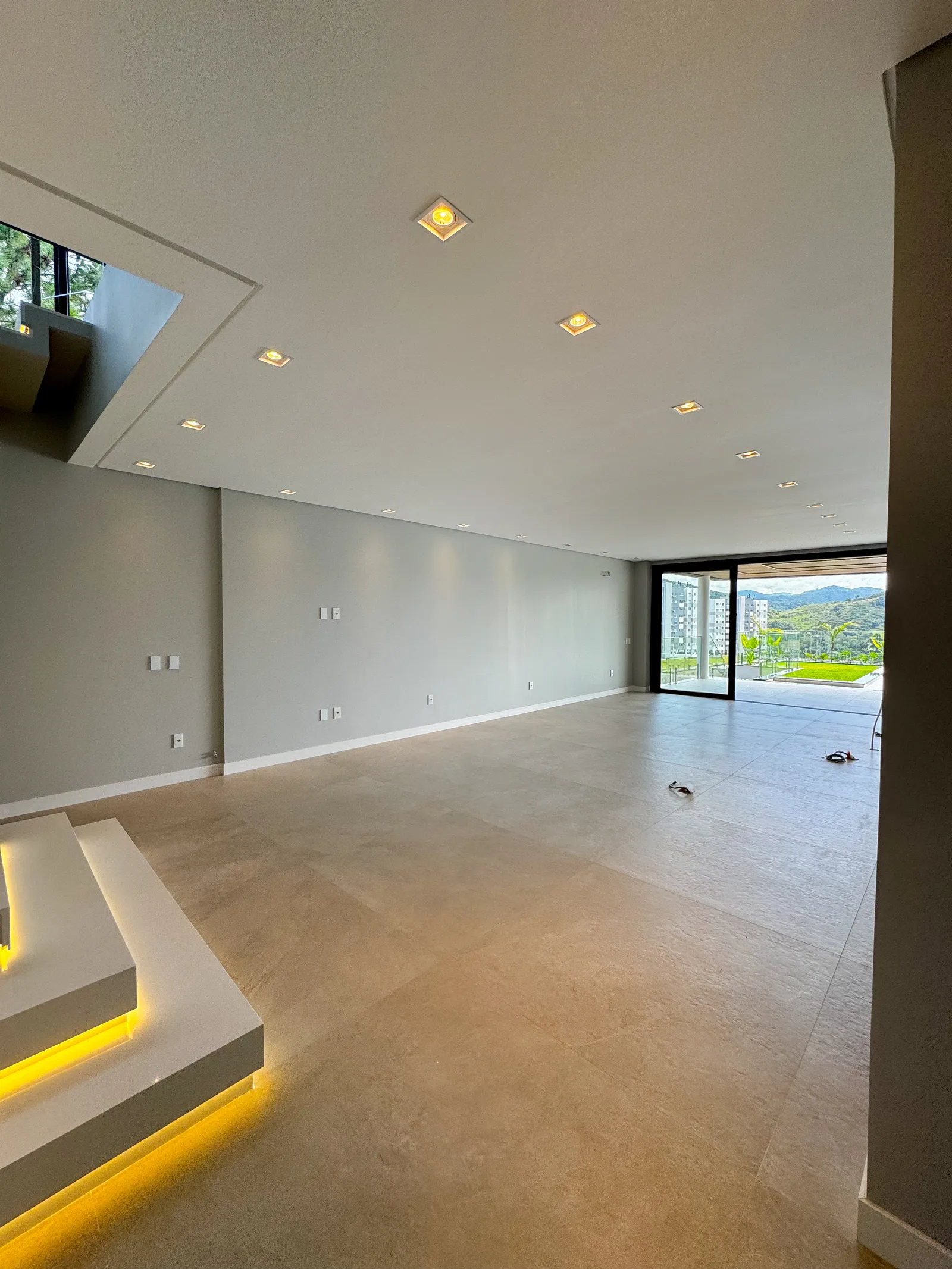 Amplo living da Casa Van Gogh com iluminação embutida e vista aberta