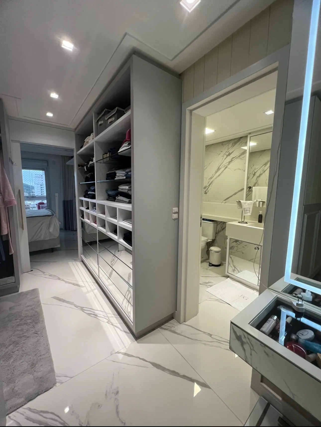 Closet amplo integrado à suíte, com bancada em mármore